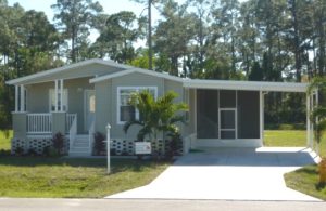 Front view of a house with stairs, screen room and carport