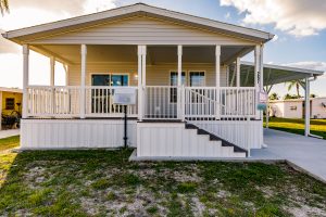 Front view of a house with a patio, stairs and a carport