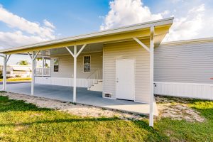 Side view of a house with a carport, stairs and a shed
