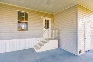 Angled view of a house with stairs and a shed