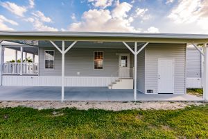 Side view of a house with a carport, stairs and a shed