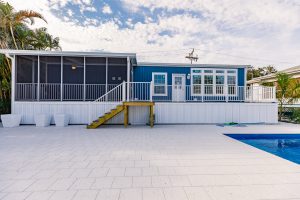 Side view of a house with stairs and a screen room