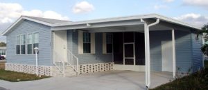 Angled view of a house with a screen room, stairs and a shed
