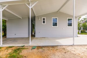 Back view of a house with a shed and carport