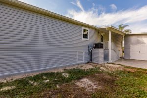 Angled view of a house with stairs and a shed