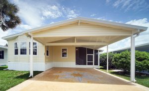 Front view of a house with stairs, screen room and carport