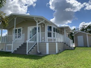 Angled view of a house with stairs and a shed