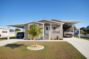 Front view of a house with a carport, an RV port and stairs